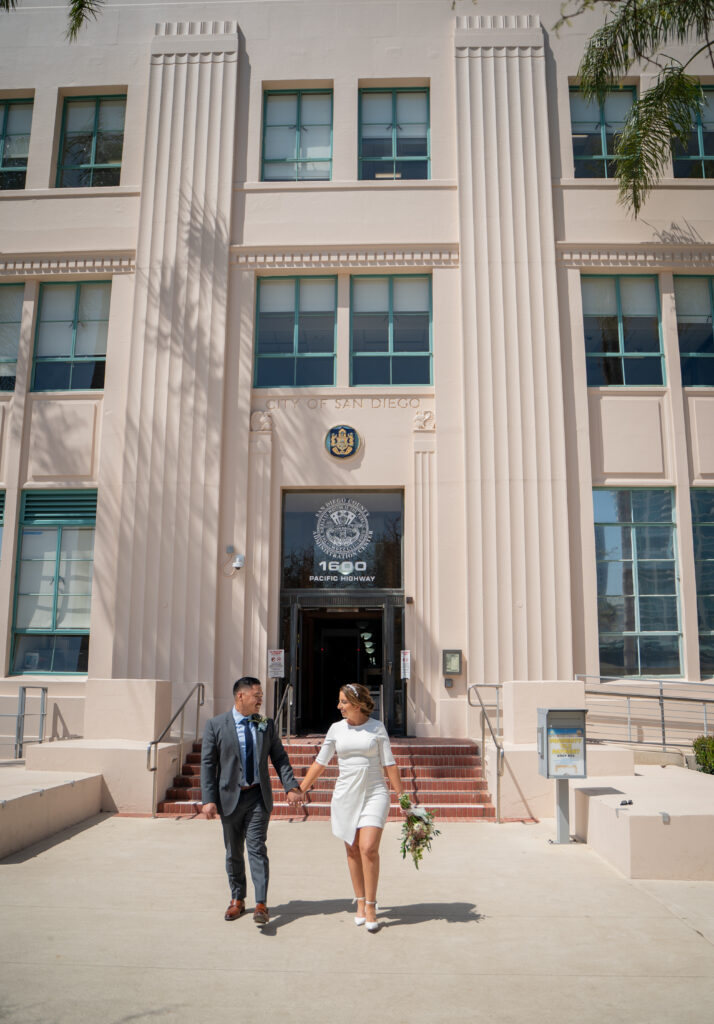 Couple walking hand in hand leaving the San Diego courthouse after their intimate wedding.