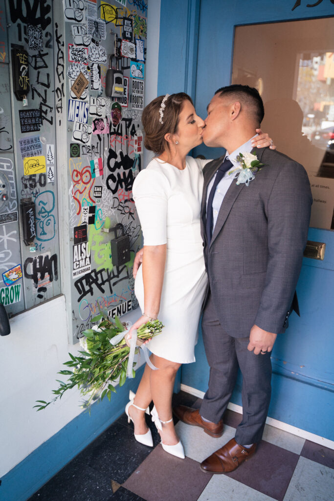 Couple kissing at Little Italy stroll photo session after their courthouse elopement.