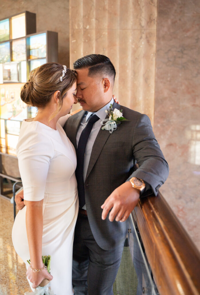 Couple embracing at San Diego courthouse on their elopement day.
