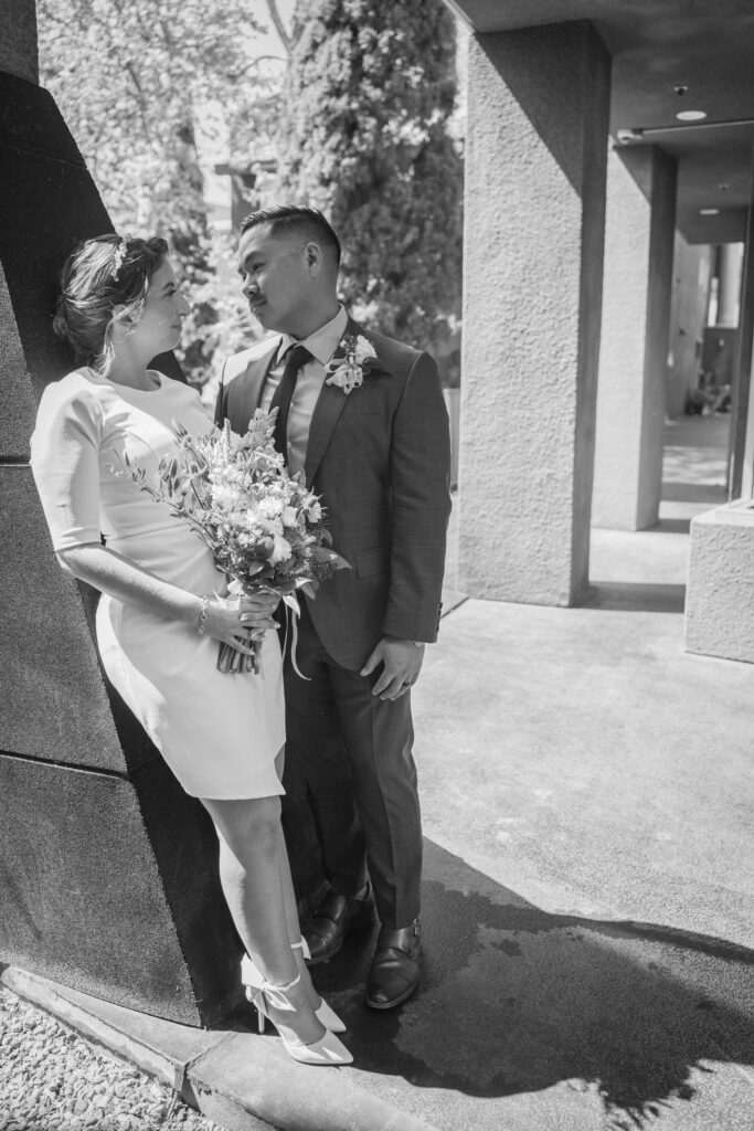Couple looking at each other at Little Italy stroll photo session after their courthouse elopement.
