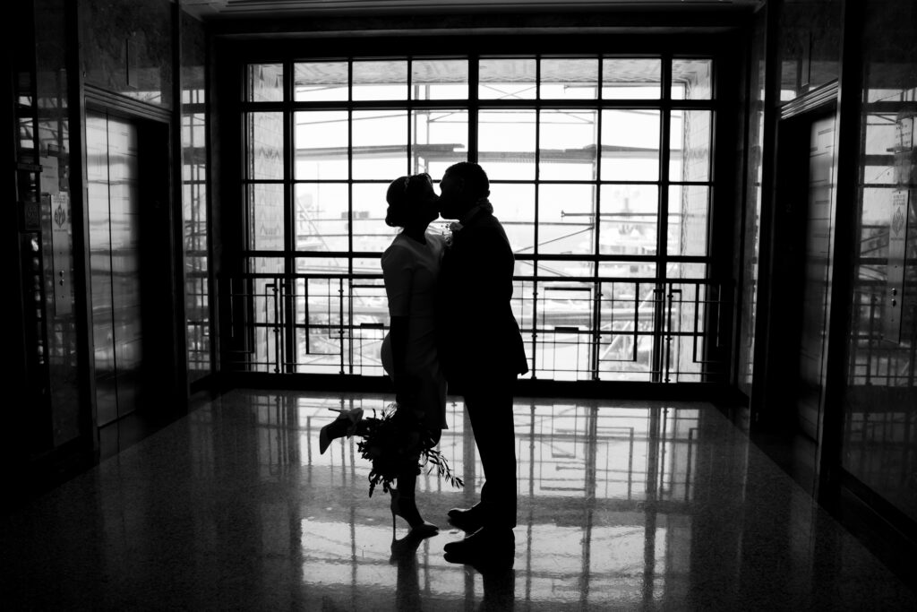 Couple kissing on wedding day at San Diego courthouse.