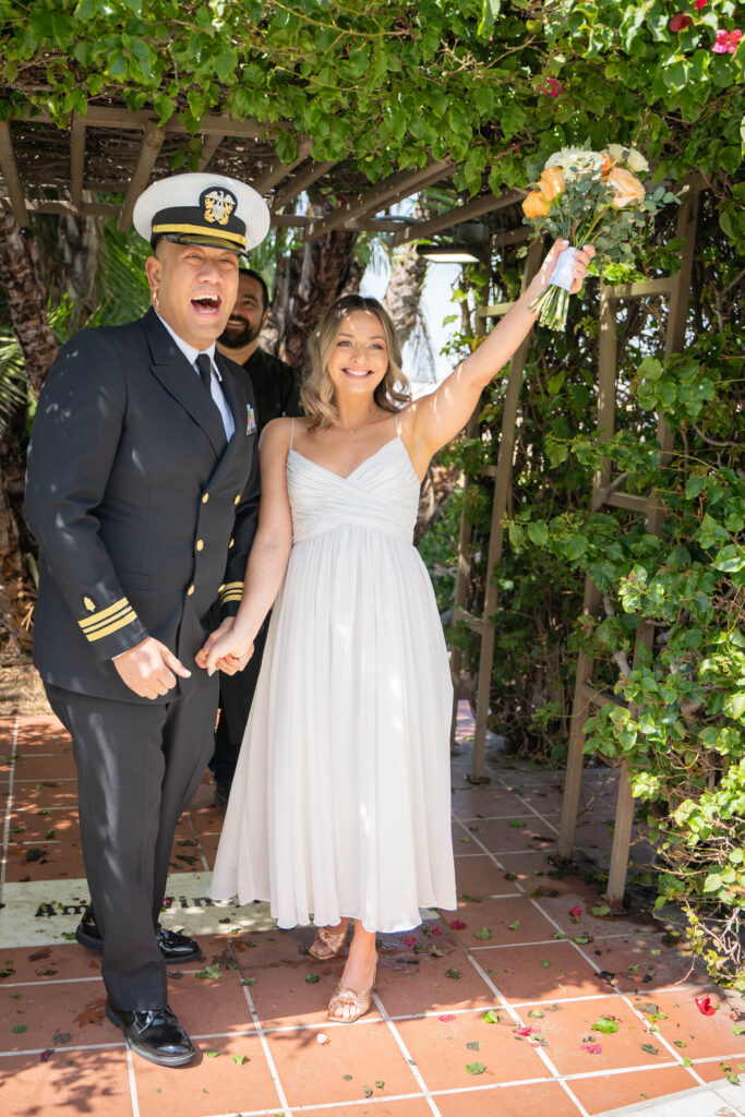 Couple celebrating and cheering after saying "I do"s at San Diego courthouse elopement.
