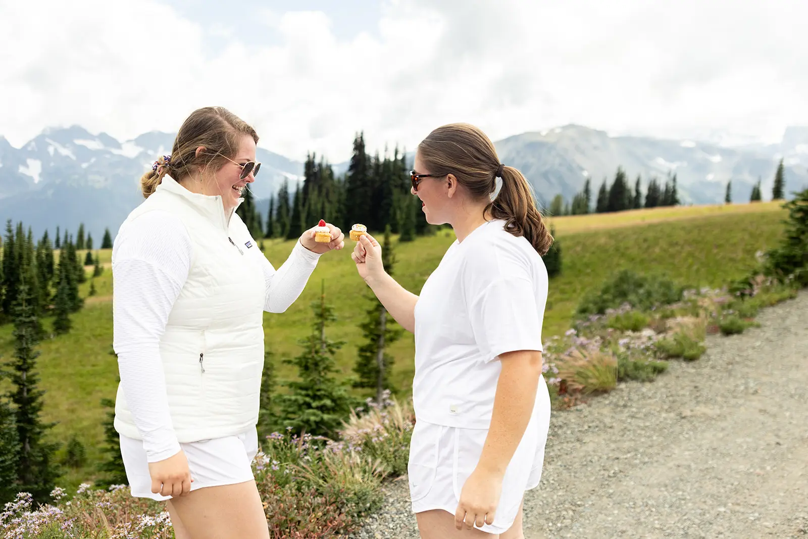 Couple toasting in a wildflower meadow with Cascade Range views near Sunrise Point, Mt. Rainier