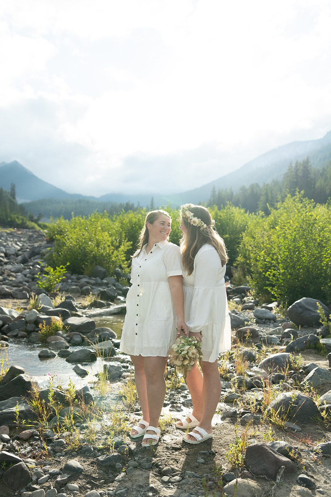 Couple standing together in the riverbed below Mt. Rainier on their elopement day
