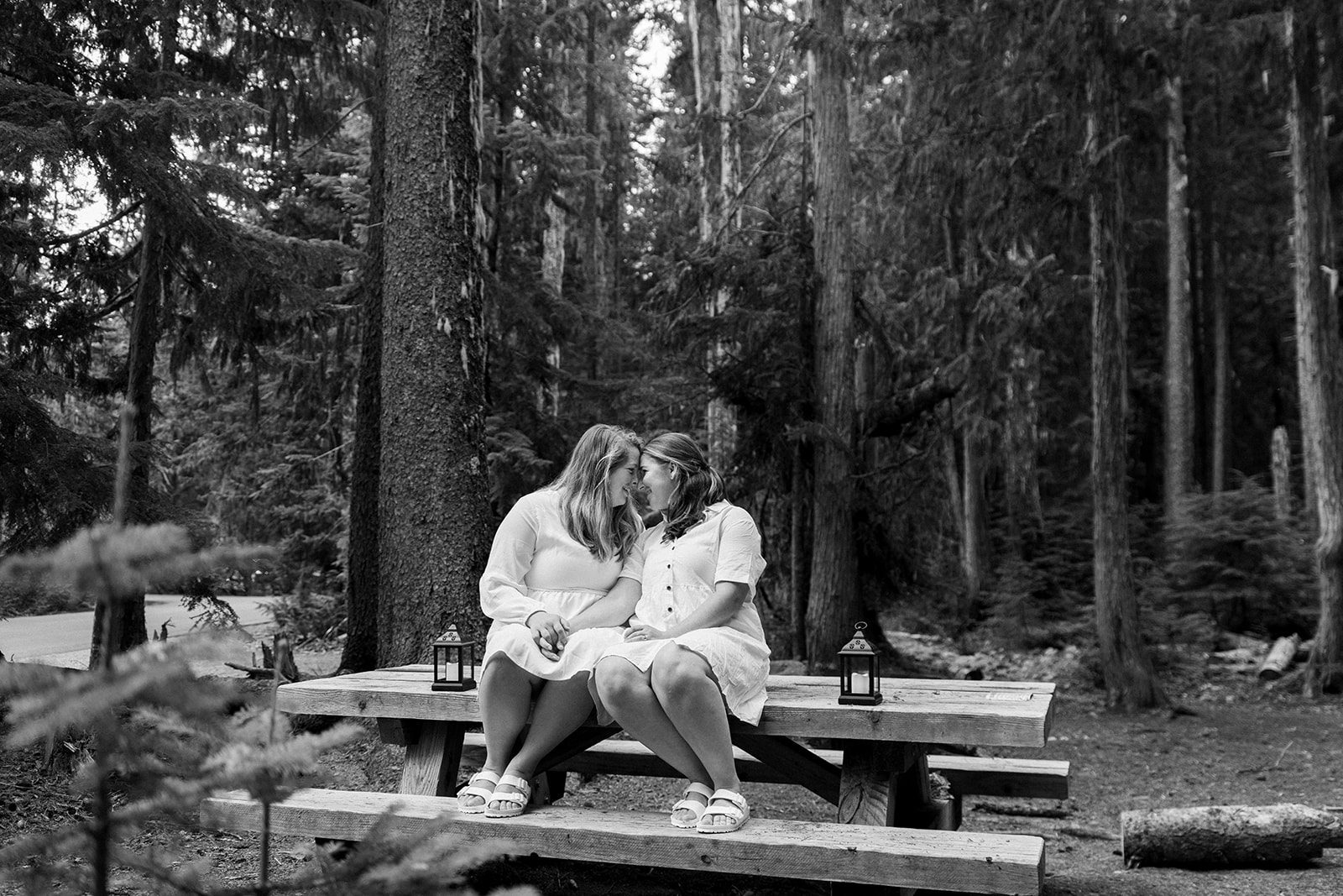 Couple sitting together by lantern light at their campsite the evening before their Mt. Rainier elopement
